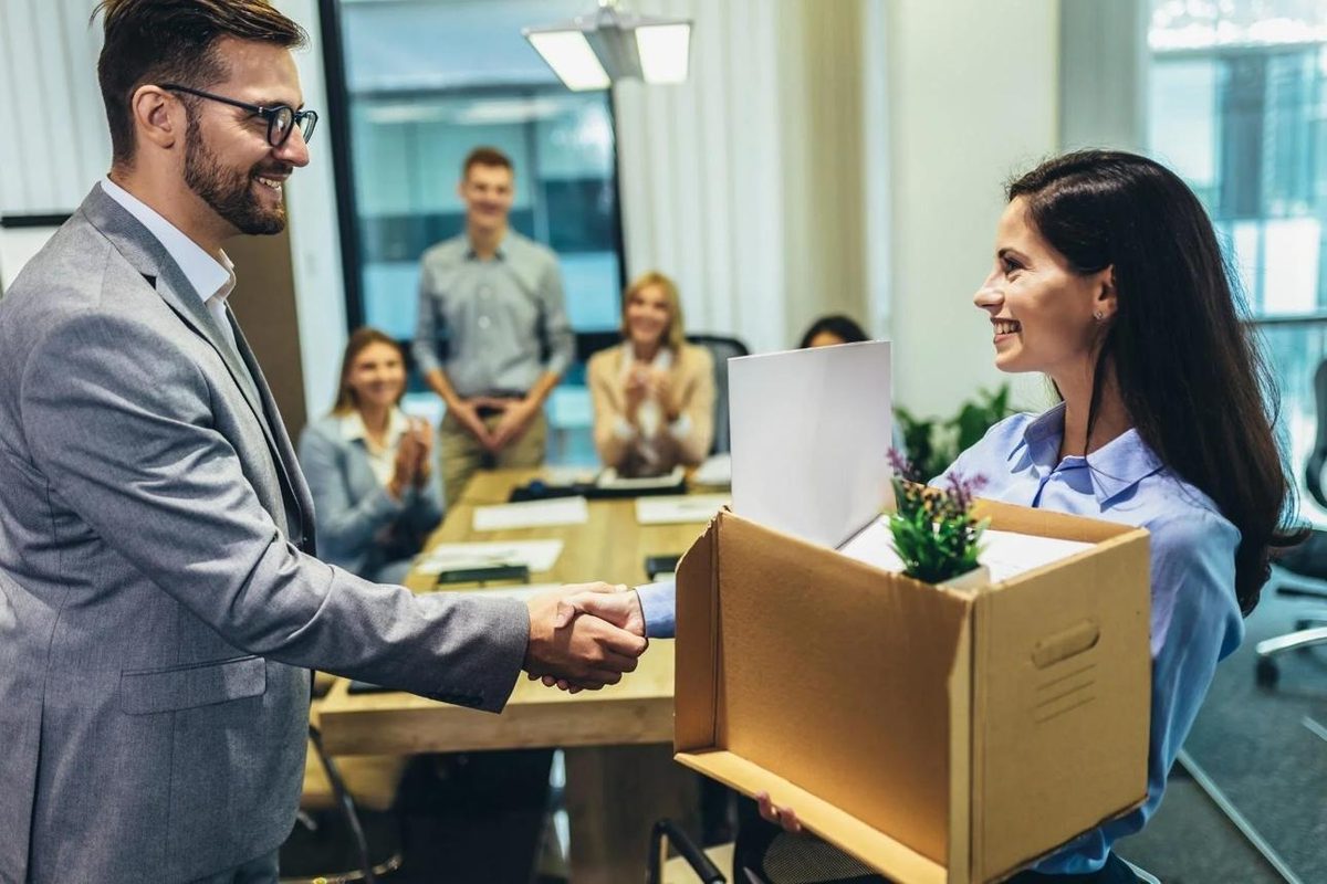 Colleagues congratulating an employee with a handshake